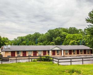 un edificio con una valla delante de un campo en Relax Inn Saint Charles, en St. Charles