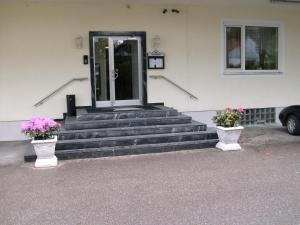 eine Haustür eines Hauses mit zwei Vasen mit Blumen in der Unterkunft Hotel Adler in Augsburg