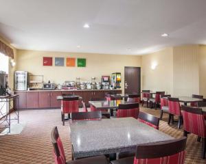una sala da pranzo con tavoli e sedie e una cucina di Comfort Inn & Suites Harrisonville a Harrisonville