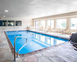 a pool in a hotel with chairs and tables at Comfort Inn Lees Summit in Lees Summit