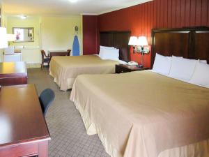 Habitación de hotel con 2 camas, mesa y sillas en Rodeway Inn, en Kansas City