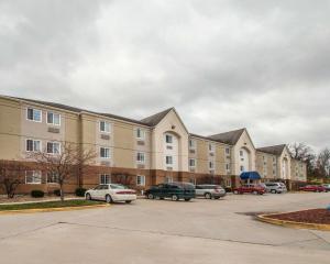 a large apartment building with cars parked in a parking lot at Suburban Studios Columbia - Hwy 63 & I-70 in Columbia