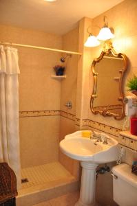 
a bathroom with a sink, toilet, mirror and bath tub at The Eagle Inn in Santa Barbara
