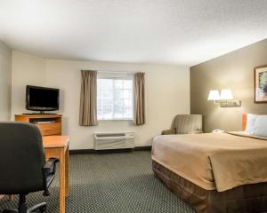 a hotel room with a bed and a television at Suburban Studios Columbia - Hwy 63 & I-70 in Columbia