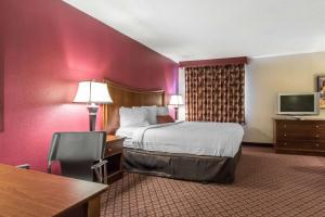 A bed or beds in a room at Econo Lodge Inn & Suites Joplin