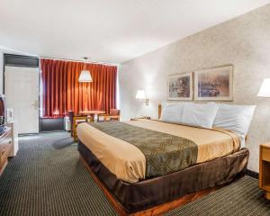 una camera d'albergo con un letto grande e una scrivania di Econo Lodge Jefferson City a Jefferson City