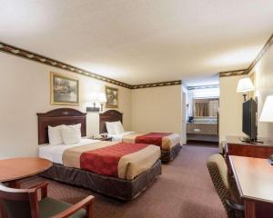 a hotel room with two beds and a desk at Econo Lodge Grenada in Grenada +20 photos