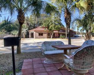 a patio with a table and chairs and palm trees at Twin Star Lodge in Biloxi