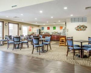 a restaurant with tables and chairs and a kitchen at Comfort Inn Poplar Bluff North in Poplar Bluff