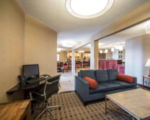 a living room with a blue couch and a desk at Quality Inn & Suites Boonville - Columbia in Boonville