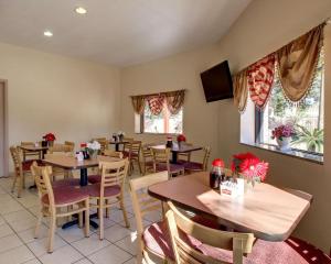 un restaurante con mesas, sillas y TV en Twin Star Lodge en Biloxi