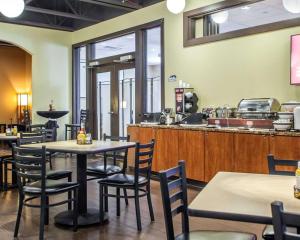 a restaurant with tables and chairs and a counter at Comfort Inn St Louis - Westport Event Center in Maryland Heights