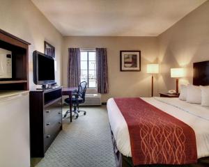 a hotel room with a bed and a desk at Columbia Inn & Suites in Columbia