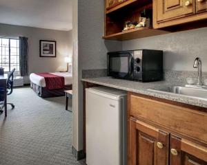 a kitchen with a microwave and a bed in a room at Columbia Inn & Suites in Columbia