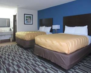 duas camas num quarto de hotel com paredes azuis em Quality Inn Farmington em Farmington