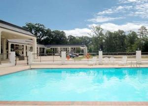 een groot zwembad met stoelen en een huis bij Econo Lodge Pearl - Jackson in Pearl