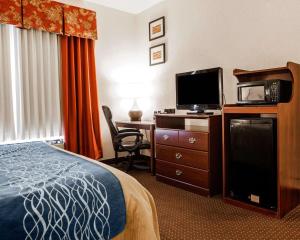 a hotel room with a bed and a desk with a tv at Quality Inn Kingdom City, MO in Kingdom City