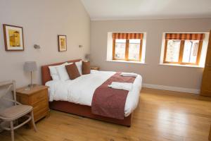 una camera con un grande letto e due finestre di Decoy Country Cottages a Navan