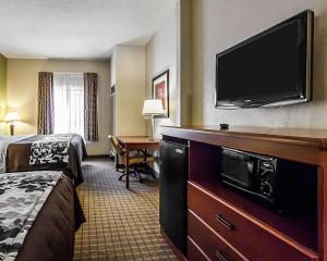 a hotel room with a bed and a flat screen tv at Sleep Inn & Suites Hattiesburg in Hattiesburg