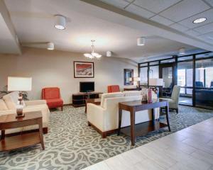 a living room with couches and chairs and a tv at Comfort Inn Moss Point Pascagoula in Moss Point