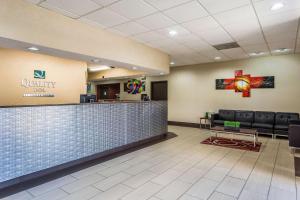 a lobby with a waiting area with a counter and chairs at Quality Inn in Tupelo