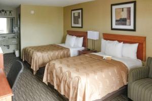 une chambre d'hôtel avec deux lits et un canapé dans l'établissement Quality Inn Columbus, à Columbus