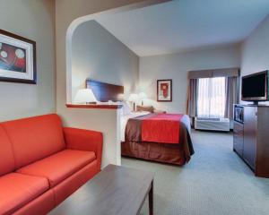a hotel room with a bed and a couch at Comfort Inn & Suites Moss Point Pascagoula in Moss Point