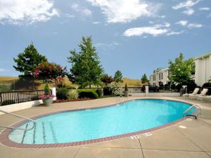 a large swimming pool in a yard with a house at Sleep Inn Horn Lake-Southaven in Horn Lake