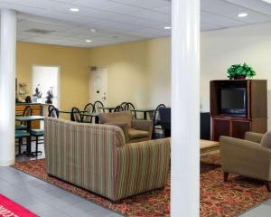 - une salle d'attente avec des canapés, une télévision et des tables dans l'établissement Econo Lodge, à Yazoo City
