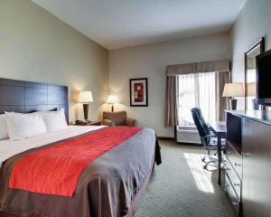 Comfort Inn Moss Point Pascagoula في موس بوينت: غرفة فندقية فيها سرير ومكتب وتلفزيون