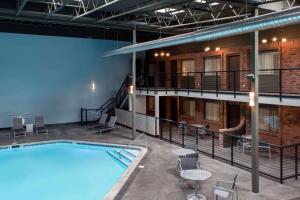 uma grande piscina num edifício com mesas e cadeiras em Copper King Convention Center, Ascend Hotel Collection em Butte