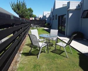 une table et des chaises assises au-dessus de l'herbe dans l'établissement Sundowner Motel, à Blenheim