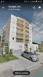a car parked in a parking lot in front of a building at Apartamento Poleto's in Bertioga