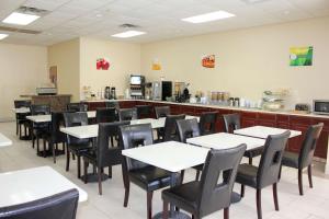 a dining room with white tables and black chairs at Americas Best Value Inn Winston-Salem in Winston-Salem