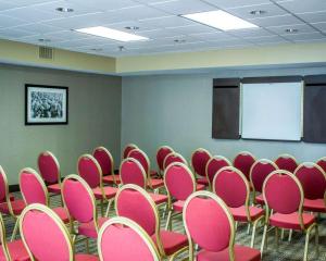a conference room with pink chairs and a whiteboard at Comfort Inn & Suites Fuquay Varina in Fuquay-Varina