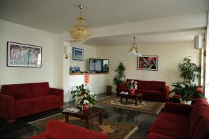 a living room with two red couches and a table at Hotel Reno in Lido di Jesolo
