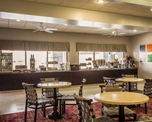 a restaurant with tables and chairs and a counter at Comfort Suites in Lumberton