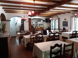 a restaurant with tables and chairs in a room at A Deolinda in Santiago do Cacém