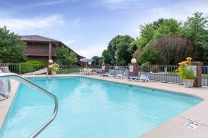 une grande piscine bleue avec des chaises et une clôture dans l'établissement Quality Inn Mount Airy Mayberry, à Mount Airy