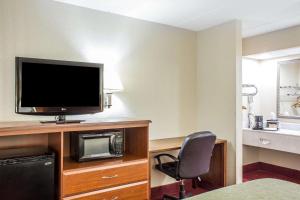 um quarto de hotel com uma televisão e uma cadeira em Quality Inn em Selma
