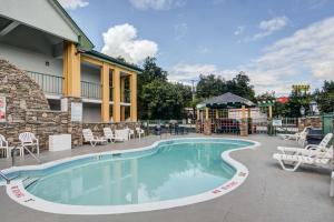 uma piscina num resort com cadeiras e mesas em Quality Inn & Suites Biltmore East em Asheville
