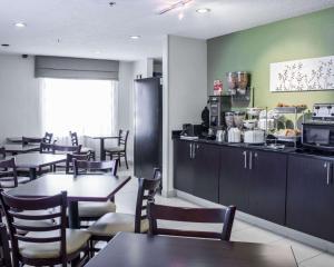 a dining room with tables and chairs and a kitchen at Sleep Inn Garner - Clayton in Garner