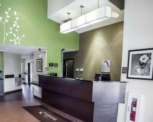 a hotel lobby with a reception desk and green walls at Sleep Inn Garner - Clayton in Garner