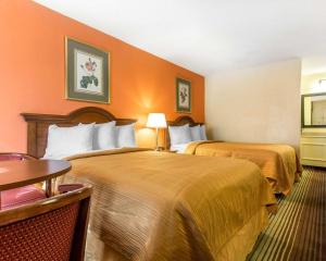 una habitación de hotel con dos camas y una mesa en Townhouse Winston Salem - University, en Winston-Salem 21 fotos más