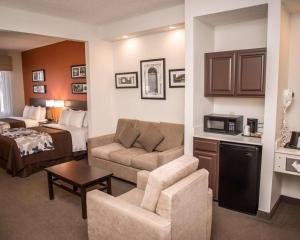 a hotel room with a bed and a living room at Sleep Inn & Suites at Concord Mills in Concord