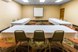 una sala de conferencias con mesas y sillas blancas y una pizarra en Quality Inn West of Asheville, en Canton