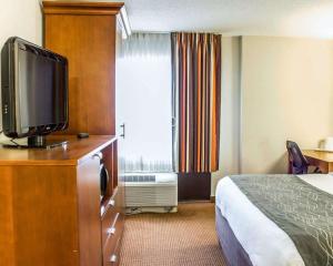 a hotel room with a bed and a flat screen tv at Comfort Inn Fayetteville West Near Fort Liberty in Fayetteville