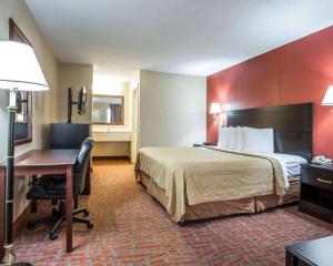 a hotel room with a bed and a desk at Quality Inn & Suites Monroe in Monroe