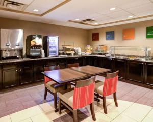 a restaurant with a table and chairs and a counter at Comfort Suites Charlotte Airport in Charlotte