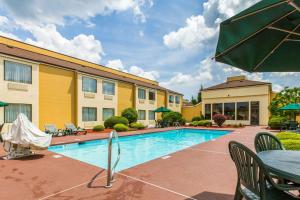 Quality Inn West of Asheville في كانتون: مسبح في الفندق مع طاولة وكراسي